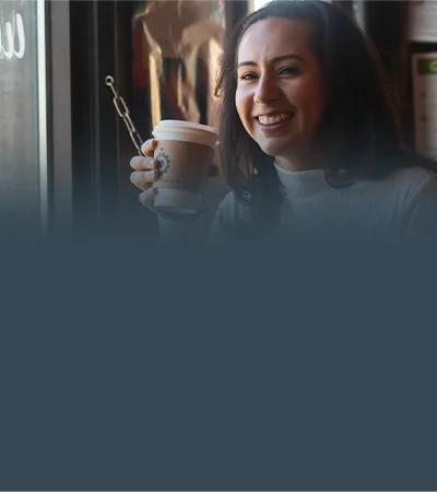 Customer smiling with a Back of the Yards coffee cup